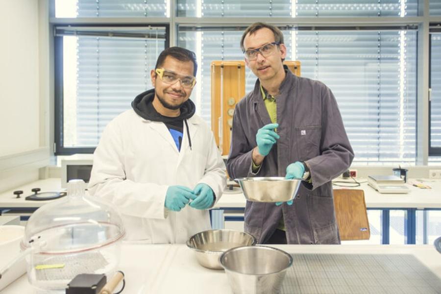 Kazi Nafiul Hassan (l.) und Conrad Dorer prüfen den gesiebten Sand im Hochschullabor. Foto: Matthias Piekacz